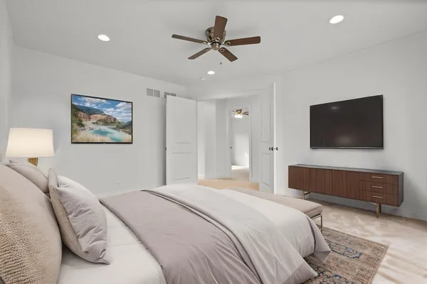 a bedroom with a bed a mirror and a flat screen tv