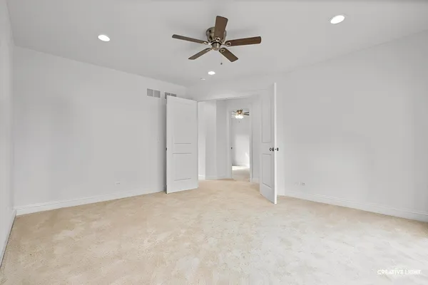 an empty room with ceiling fan and window