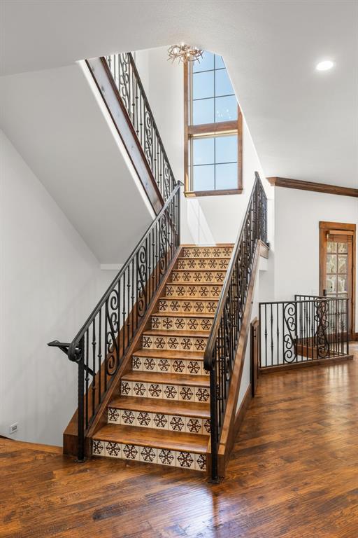 1180 McReynolds Road Sanger, TX 76266 - Photo 13 of 40 Grand staircase featuring ornate wrought iron railings, patterned risers, and rich wood treads