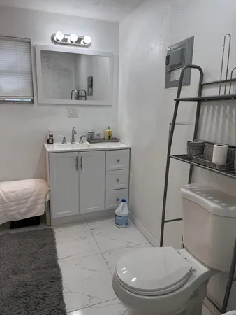a bathroom with a sink a toilet and mirror