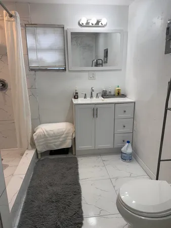 a bathroom with a sink a toilet and mirror