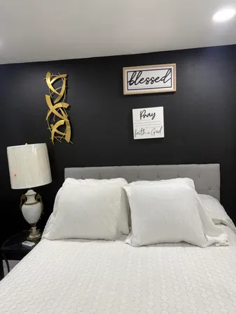 a bedroom with a bed and painting on the wall