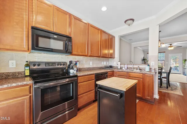 a kitchen with stainless steel appliances granite countertop wooden cabinets stove top oven and sink