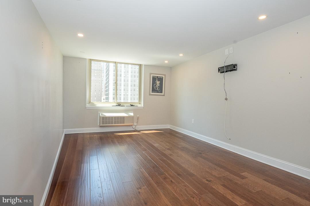 1919 Chestnut Street, Unit 807 Philadelphia, PA 19103 - Photo 12 of 25 an empty room with wooden floor and windows