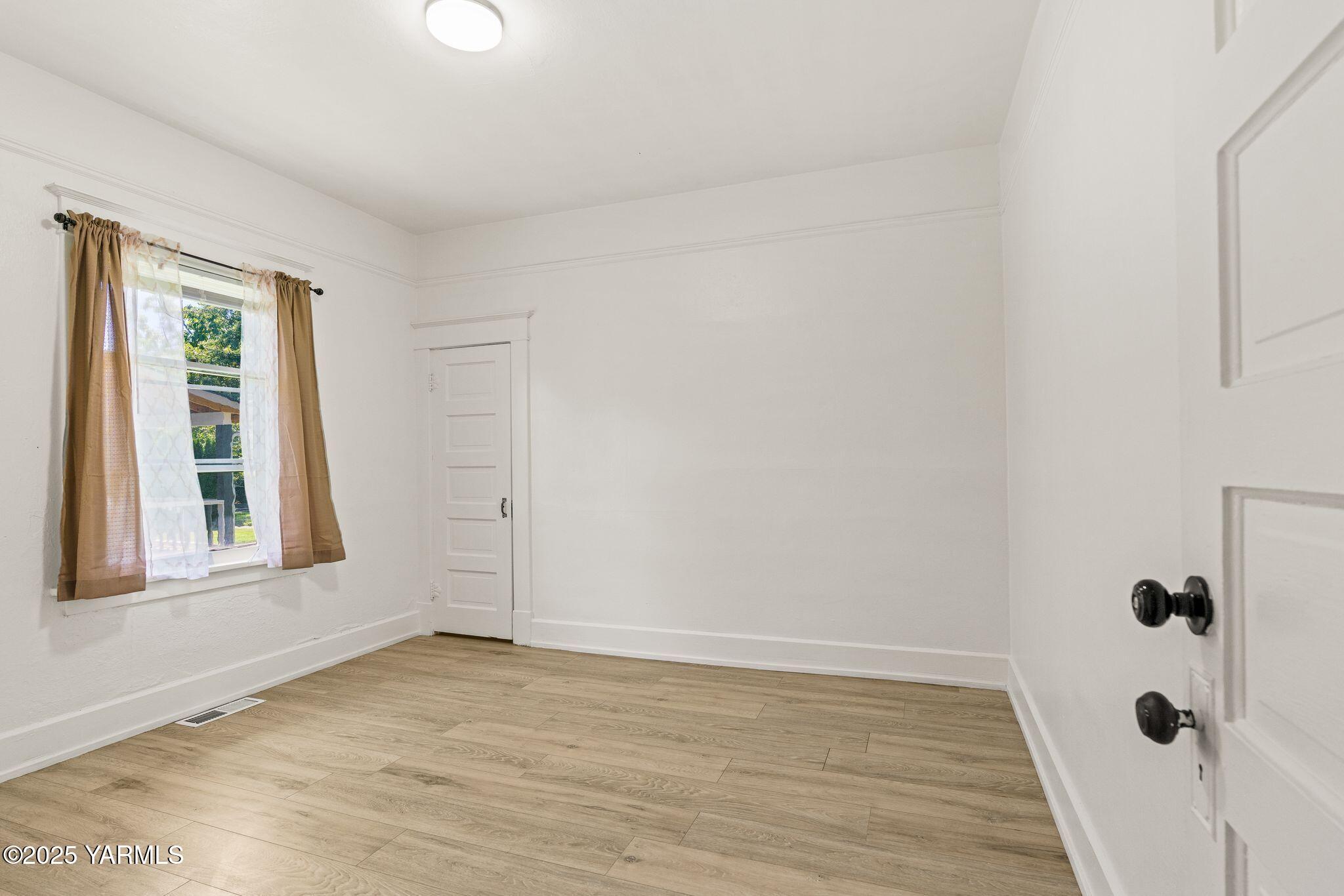 705 South 8th Avenue Yakima, WA 98902 - Photo 16 of 25 a view of an empty room with wooden floor and a window