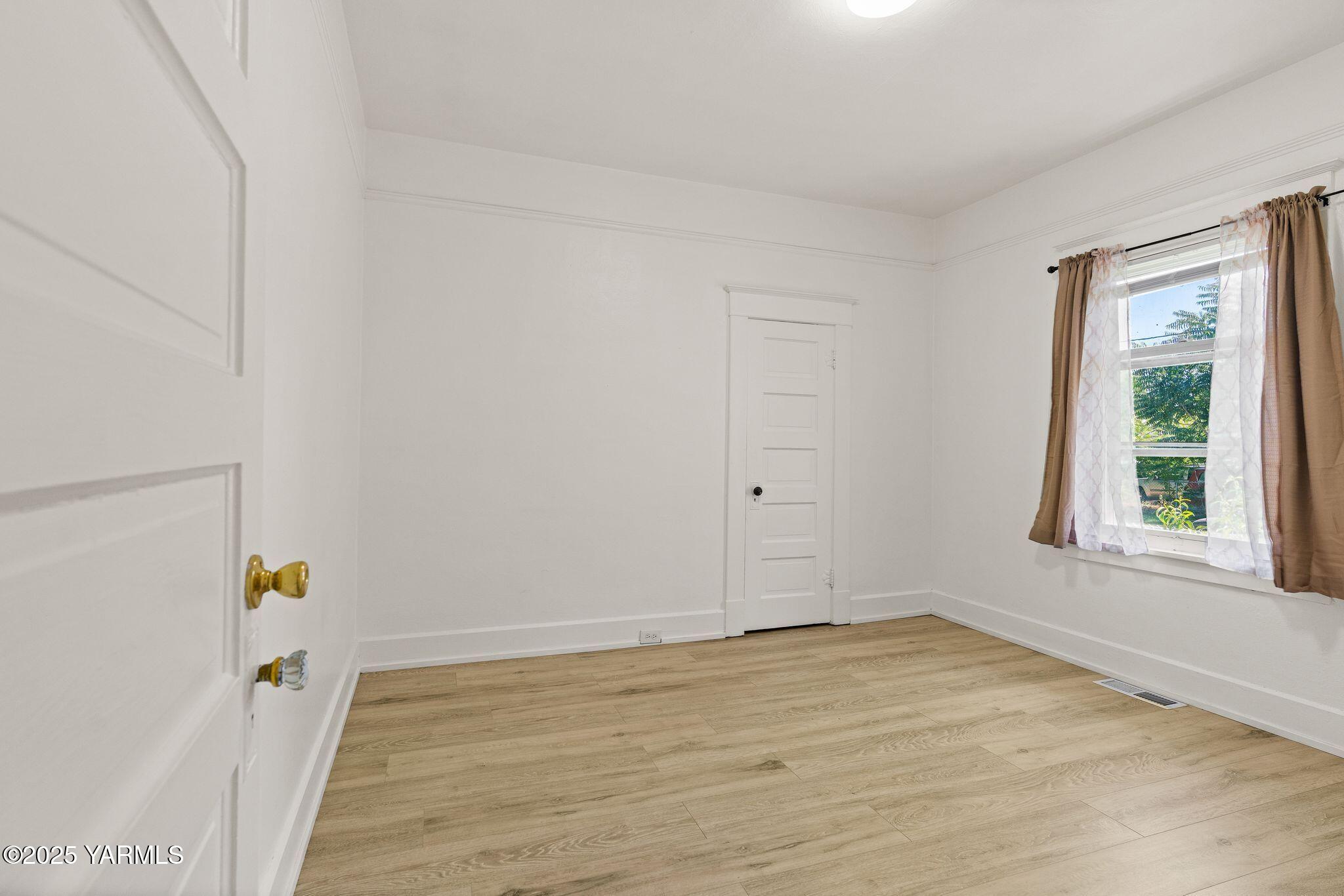 705 South 8th Avenue Yakima, WA 98902 - Photo 18 of 25 a view of an empty room with wooden floor and a window