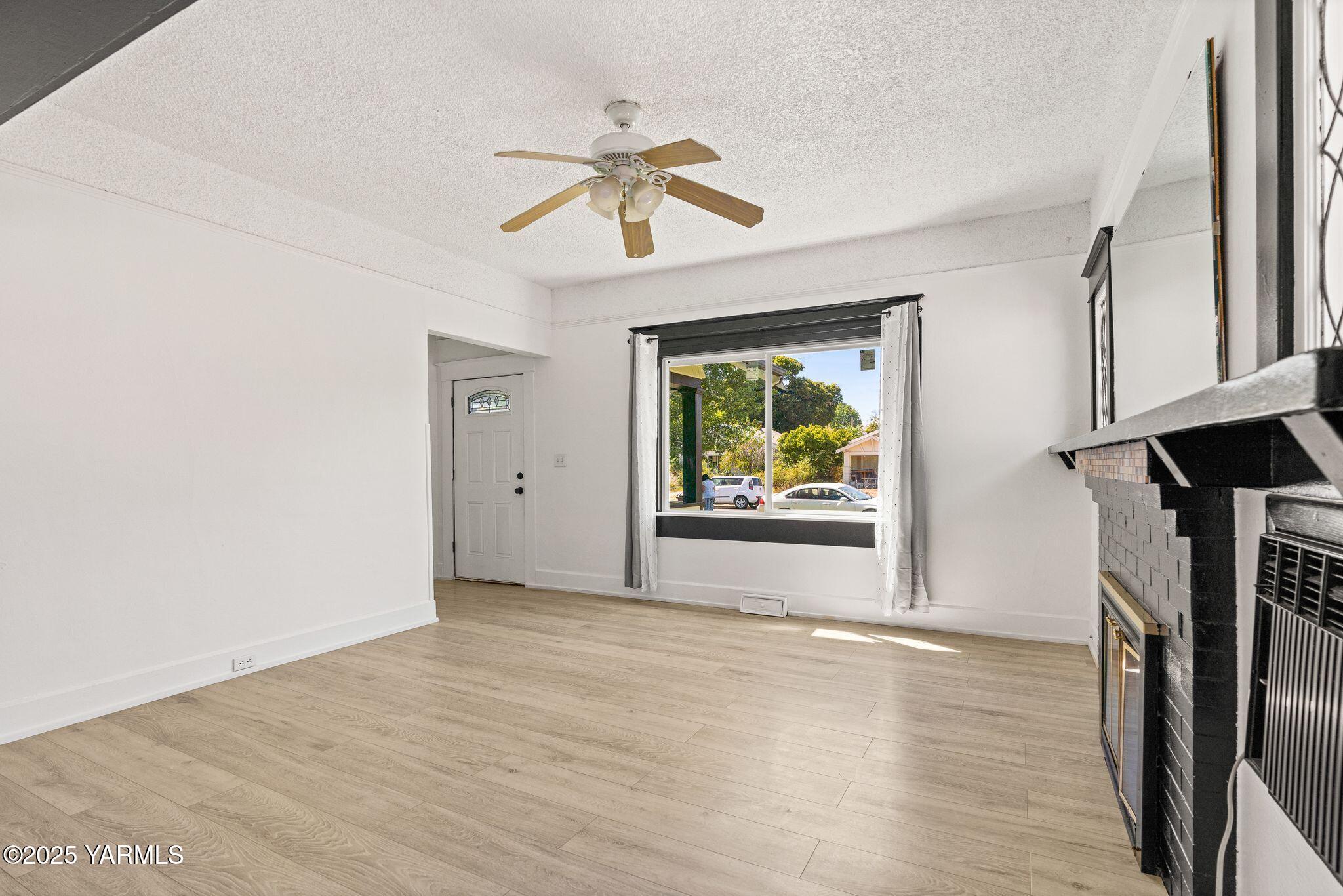 705 South 8th Avenue Yakima, WA 98902 - Photo 8 of 25 a view of an empty room with wooden floor and a window