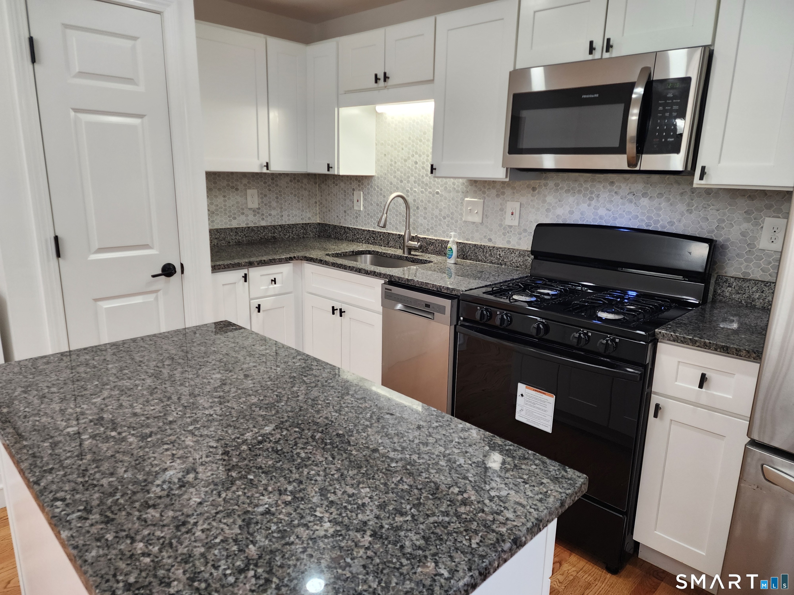71 Towne House Road, Unit 71 Hamden, CT 06514 - Photo 12 of 32 a kitchen with stainless steel appliances granite countertop a stove a sink and a microwave
