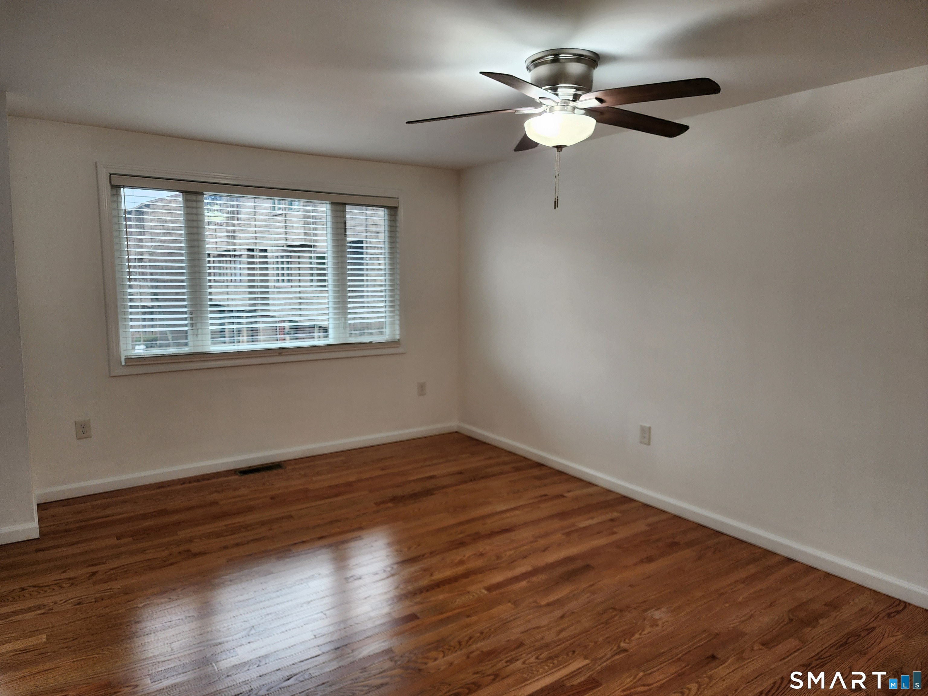 71 Towne House Road, Unit 71 Hamden, CT 06514 - Photo 18 of 32 a view of an empty room with wooden floor and a window
