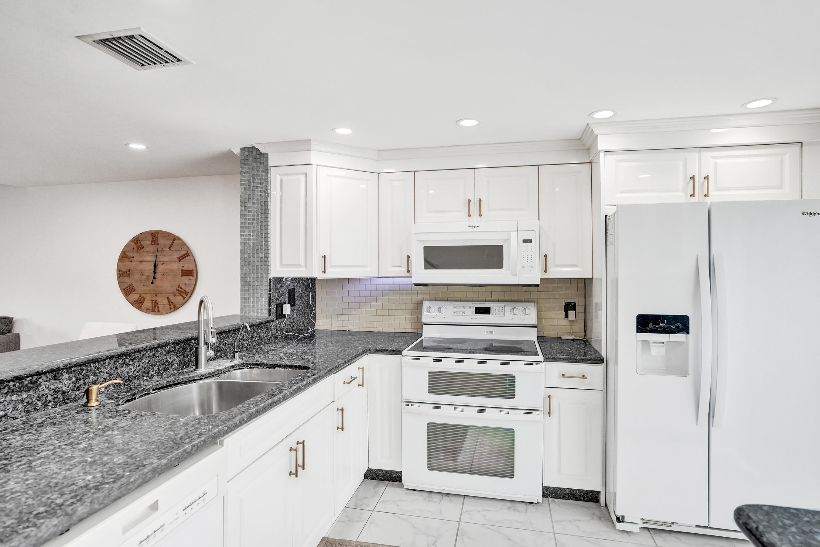 147 Southwest 3rd Street Pompano Beach, FL 33060 - Photo 5 of 29 a kitchen with stainless steel appliances granite countertop a sink stove refrigerator and cabinets