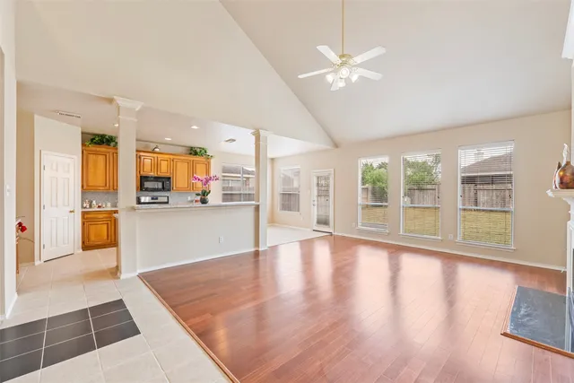 an empty room with wooden floor and outdoor kitchen