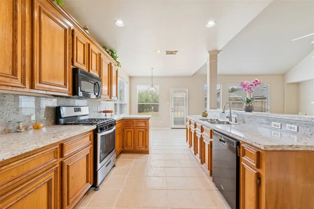 a large kitchen with stainless steel appliances granite countertop a sink and cabinets