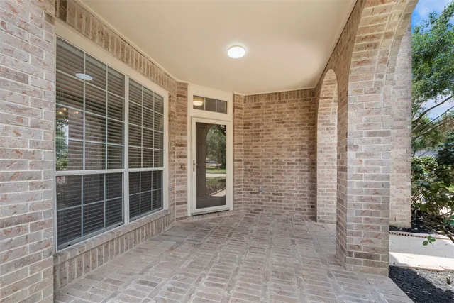 a view of an empty room with a brick wall and potted plants