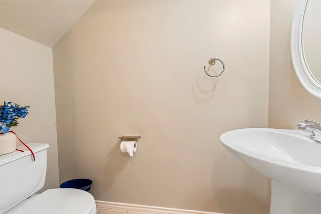 a bathroom with a sink mirror vanity and toilet
