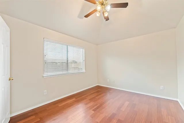 an empty room with a window and a fan