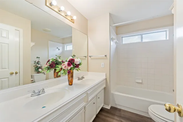 a bathroom with a tub sink and mirror