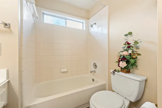a white toilet sitting next to a bath tub