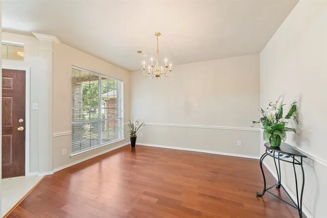 a view of a room with wooden floor and a potted plant
