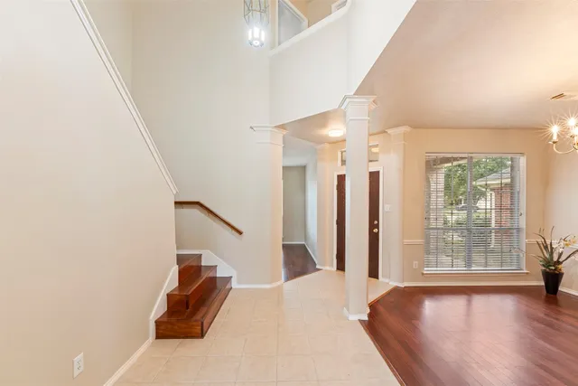 a view of a livingroom with wooden floor and stairs