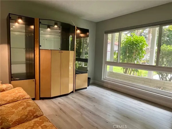 a view of a bedroom with wooden floor and windows