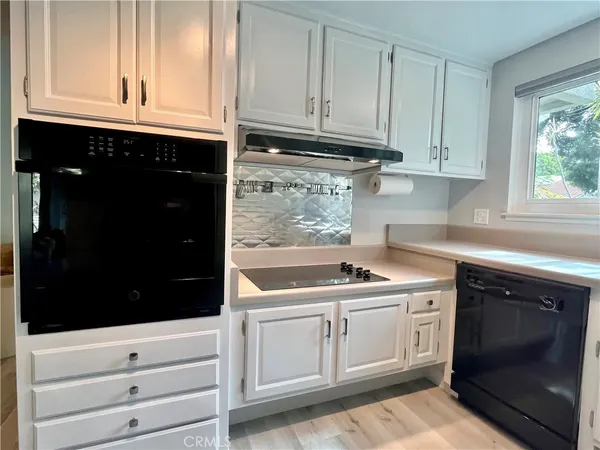 a kitchen with granite countertop white cabinets and sink