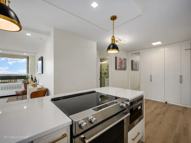 a kitchen with a stove and a chandelier