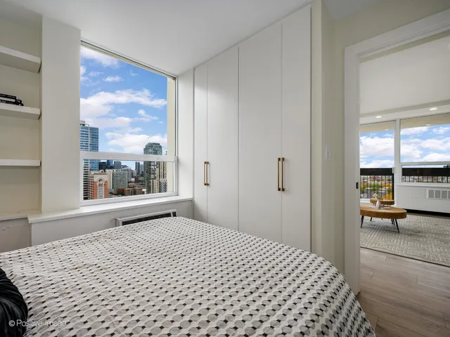 a bedroom with a bed and a large window with outer view