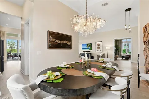 a view of a dining room with furniture a chandelier and wooden floor