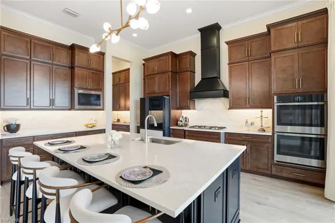 a kitchen with stainless steel appliances granite countertop a sink a stove and refrigerator