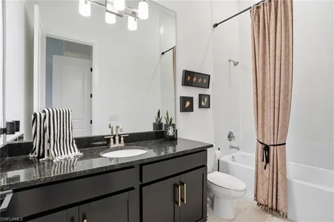 a bathroom with a double vanity sink toilet mirror and shower