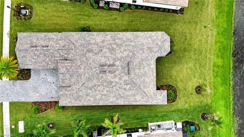 a view of a house with a yard and potted plants