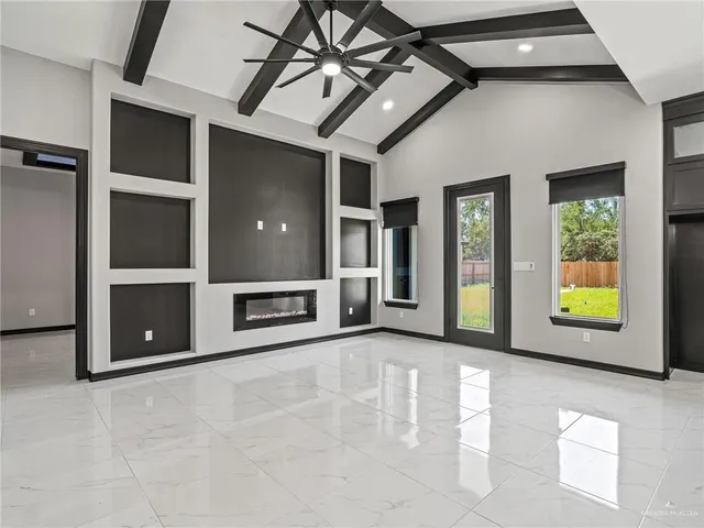 a view of an empty room with a window and fire place