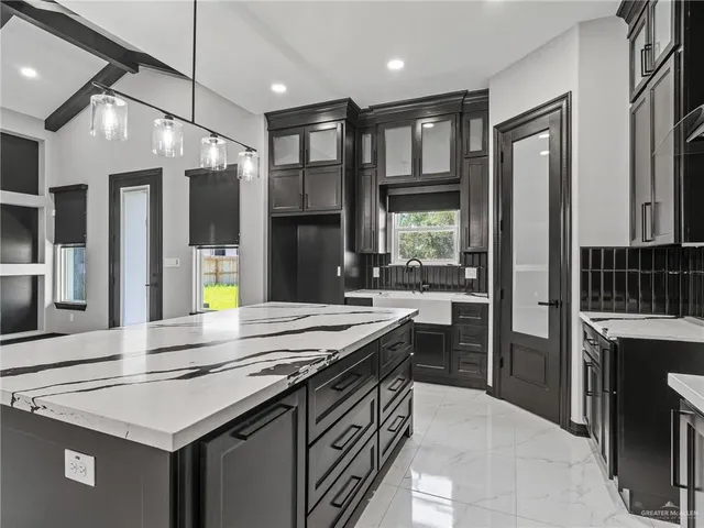 a kitchen that has a sink a stove and chairs