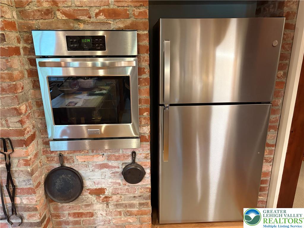 163 Goose Pond Road Canadensis, PA 18325 - Photo 10 of 12 Exposed brick surrounds modern stainless steel appliances.