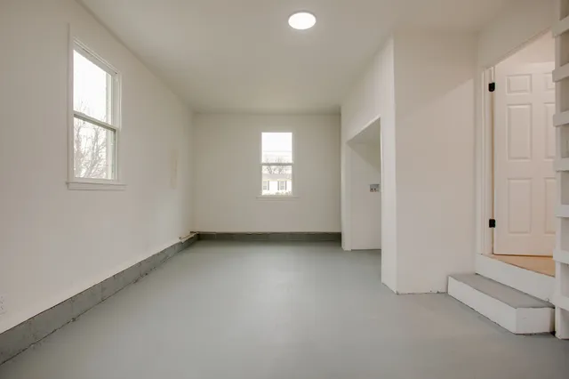 an empty room with windows and closet
