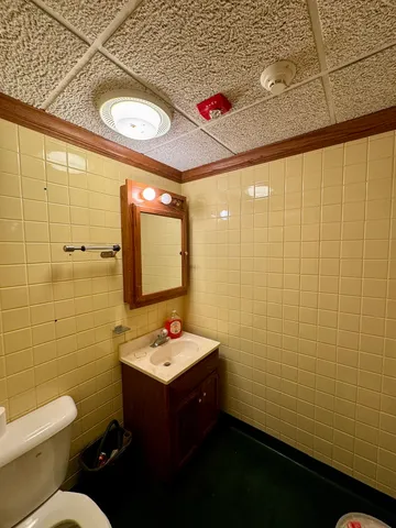 a bathroom with a toilet a sink and a mirror