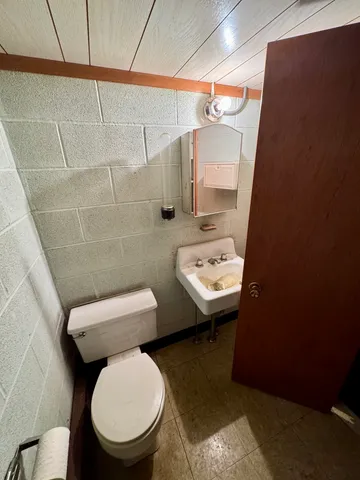 a bathroom with a sink a toilet and mirror