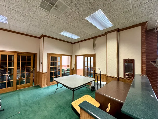 a living room with furniture pool table and chairs