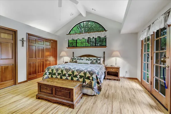 a bedroom with a bed dresser and a large window