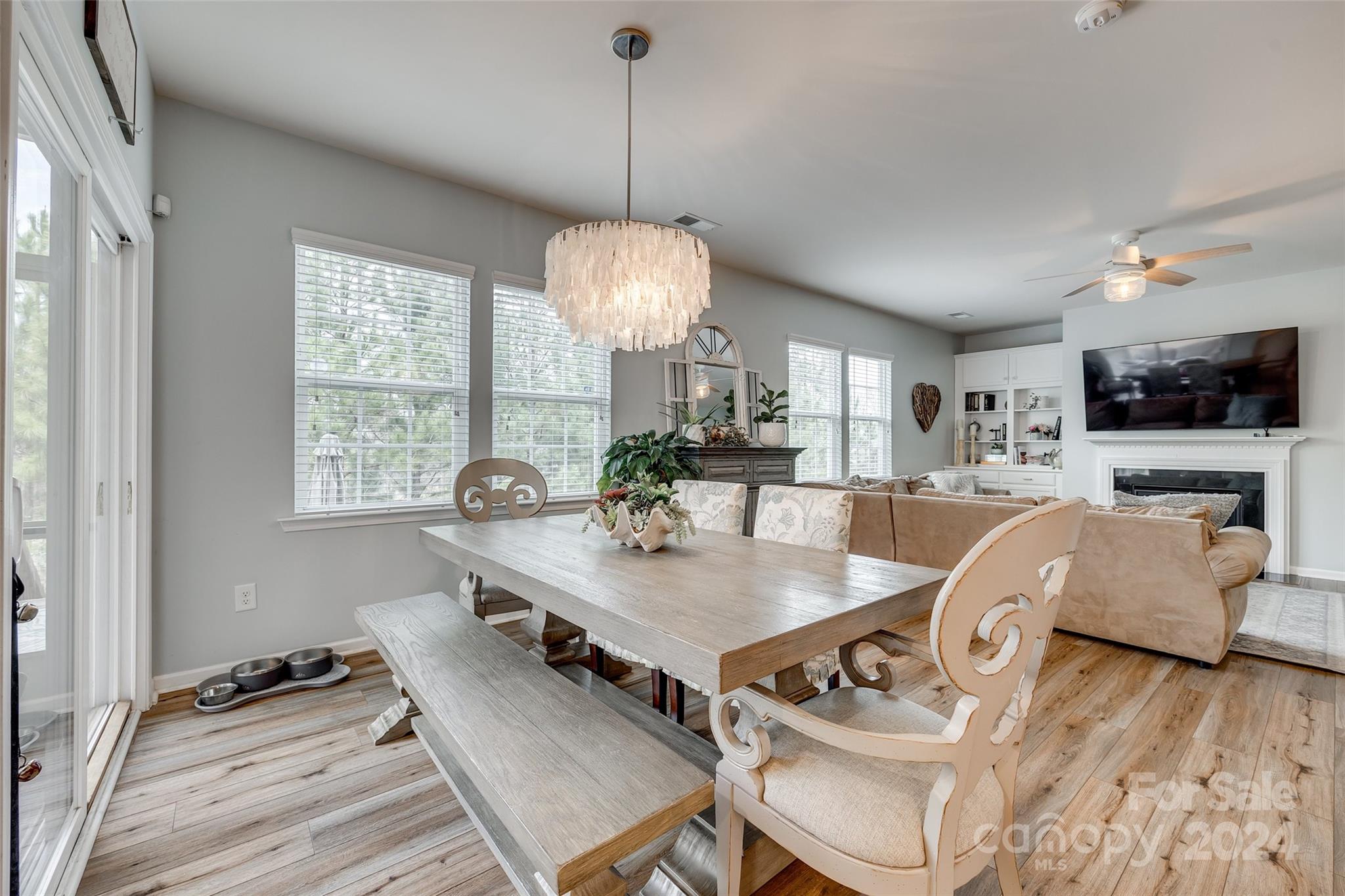2251 Elmview Lane Fort Mill, SC 29715 - Photo 12 of 46 a dining room with wooden floor a chandelier a wooden table and chairs