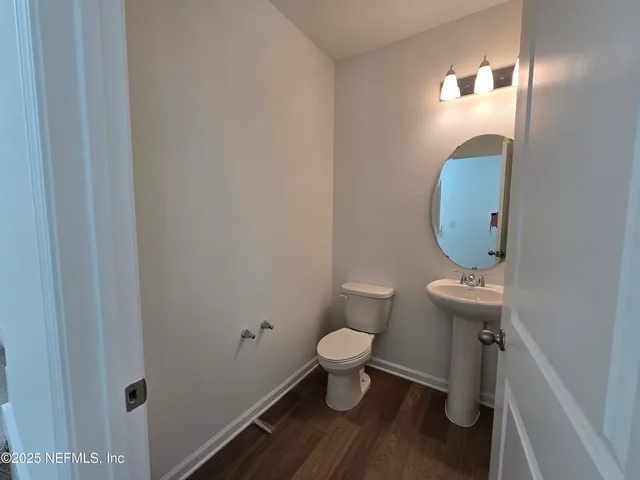 a bathroom with a sink a toilet a mirror a bathtub and shower