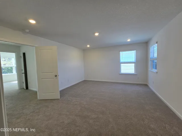 an empty room with windows and closet