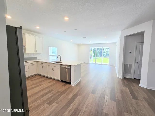 a view of a kitchen with wooden floor and a sink