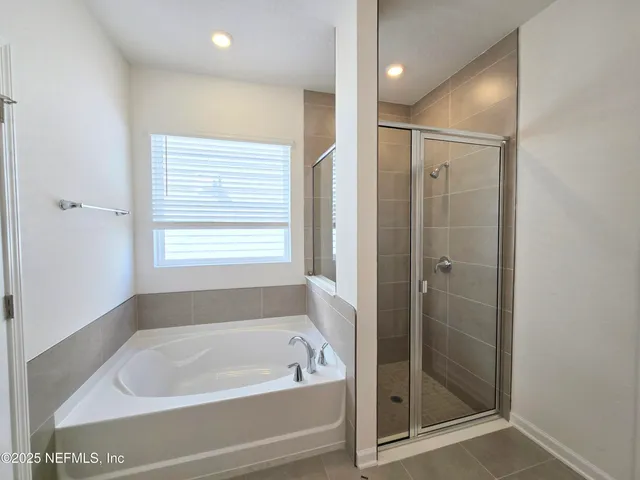 a spacious bathroom with a mirror and a sink