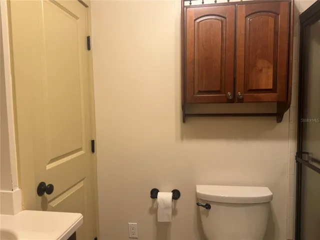 a white toilet sitting next to a shower