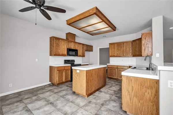 a kitchen with stainless steel appliances a stove top oven a sink a refrigerator and cabinets