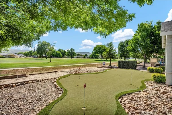 a view of a swimming pool with a lawn chairs and a big yard