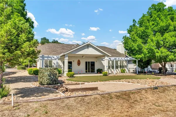 a view of a house with a yard and large tree