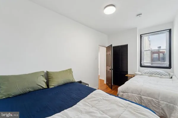 a bedroom with a bed and dresser with mirror