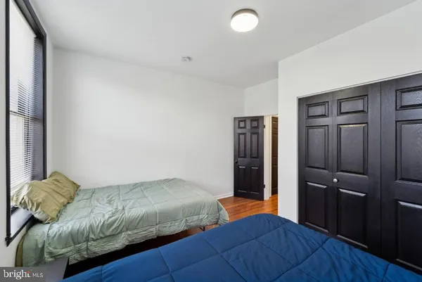 a bedroom with bed and wooden floor